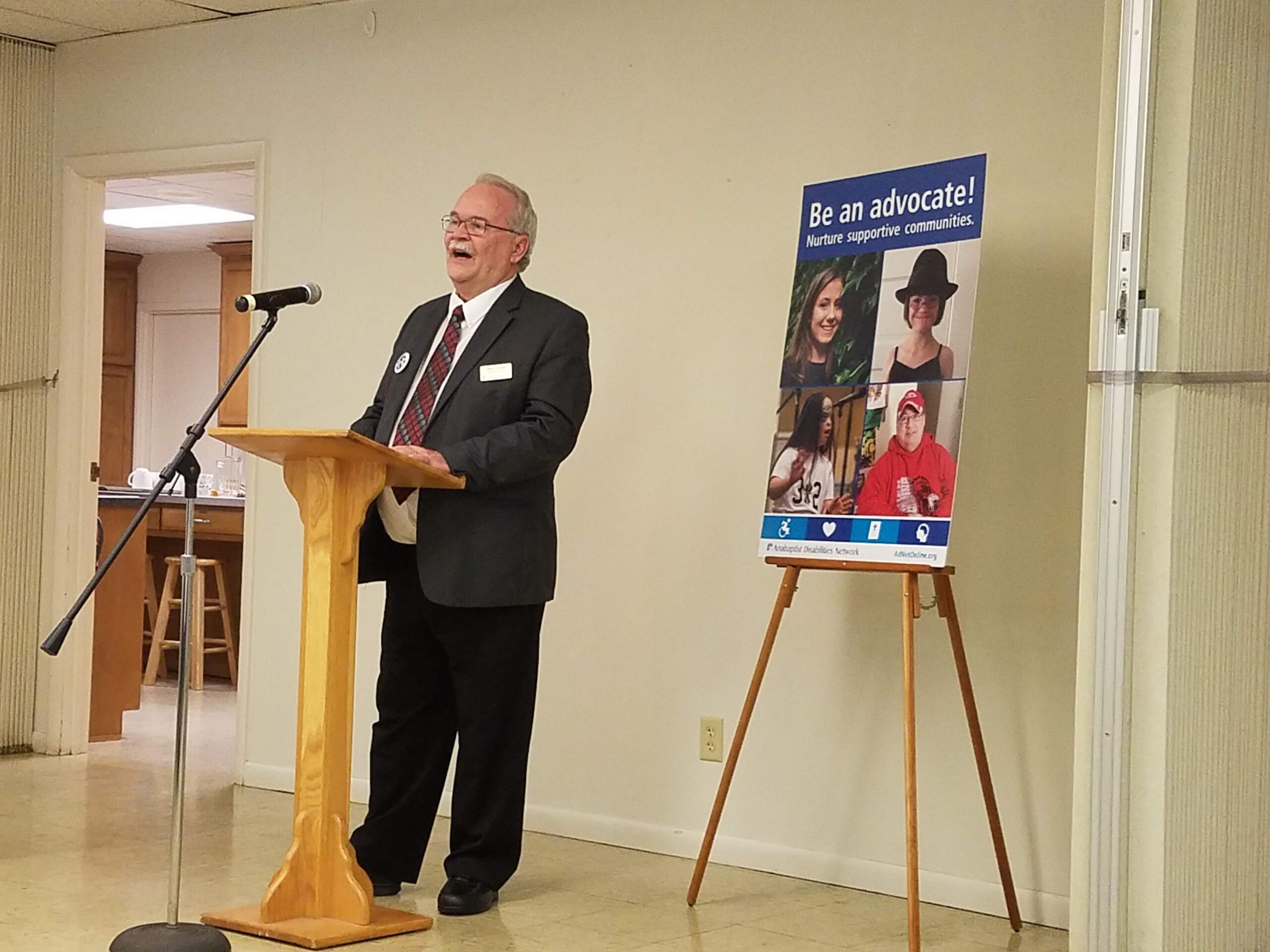 an older white man in a suit stands at a podium