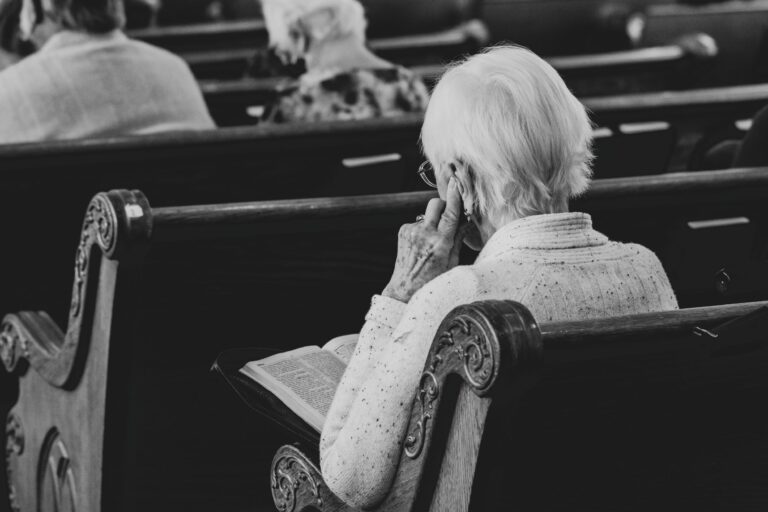 that back of an elderly person sitting in a church pew