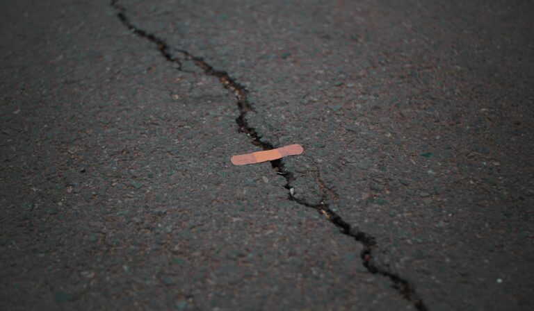 a small band aid over a large crack in pavement