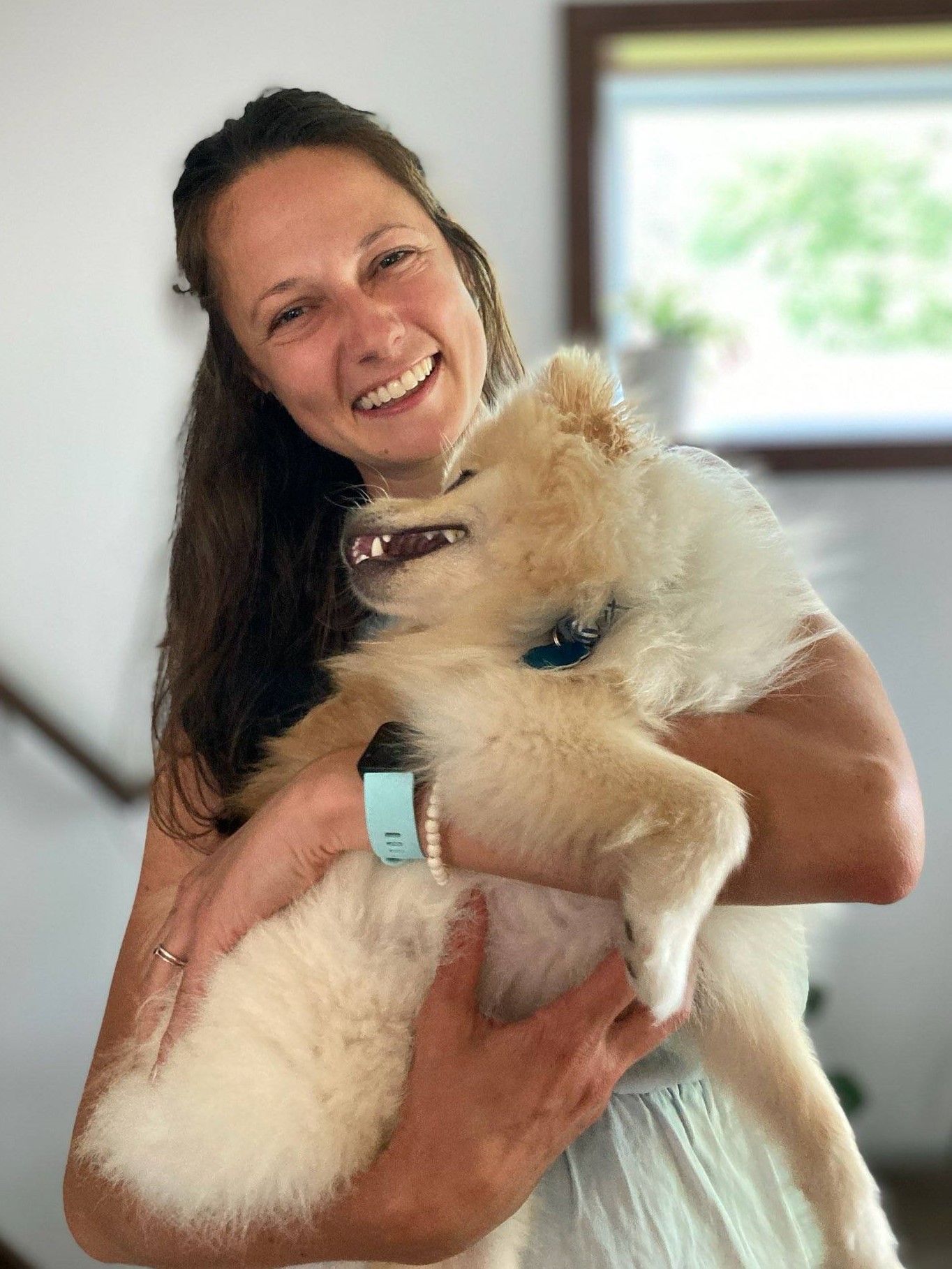 Denise Reesor is a young adult white female holding a small white dog.