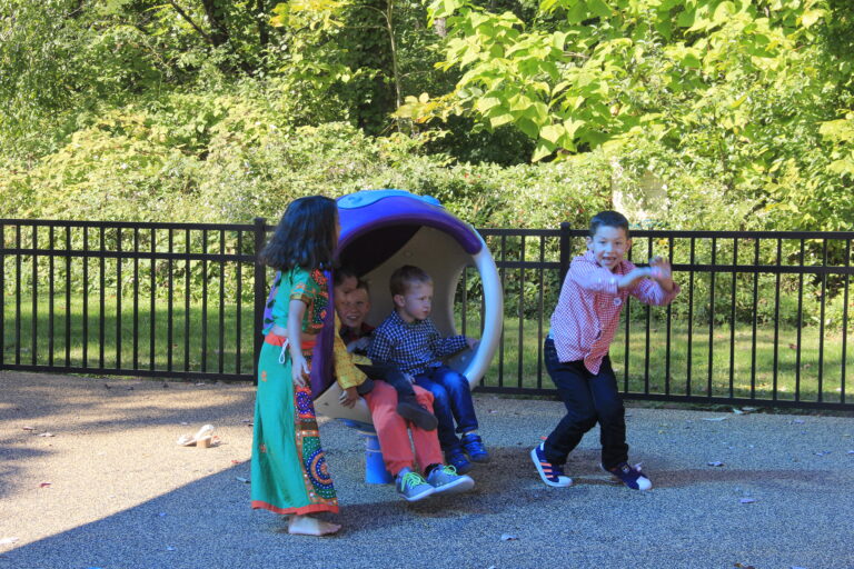 children of various ethnicities and genders play on a playground.