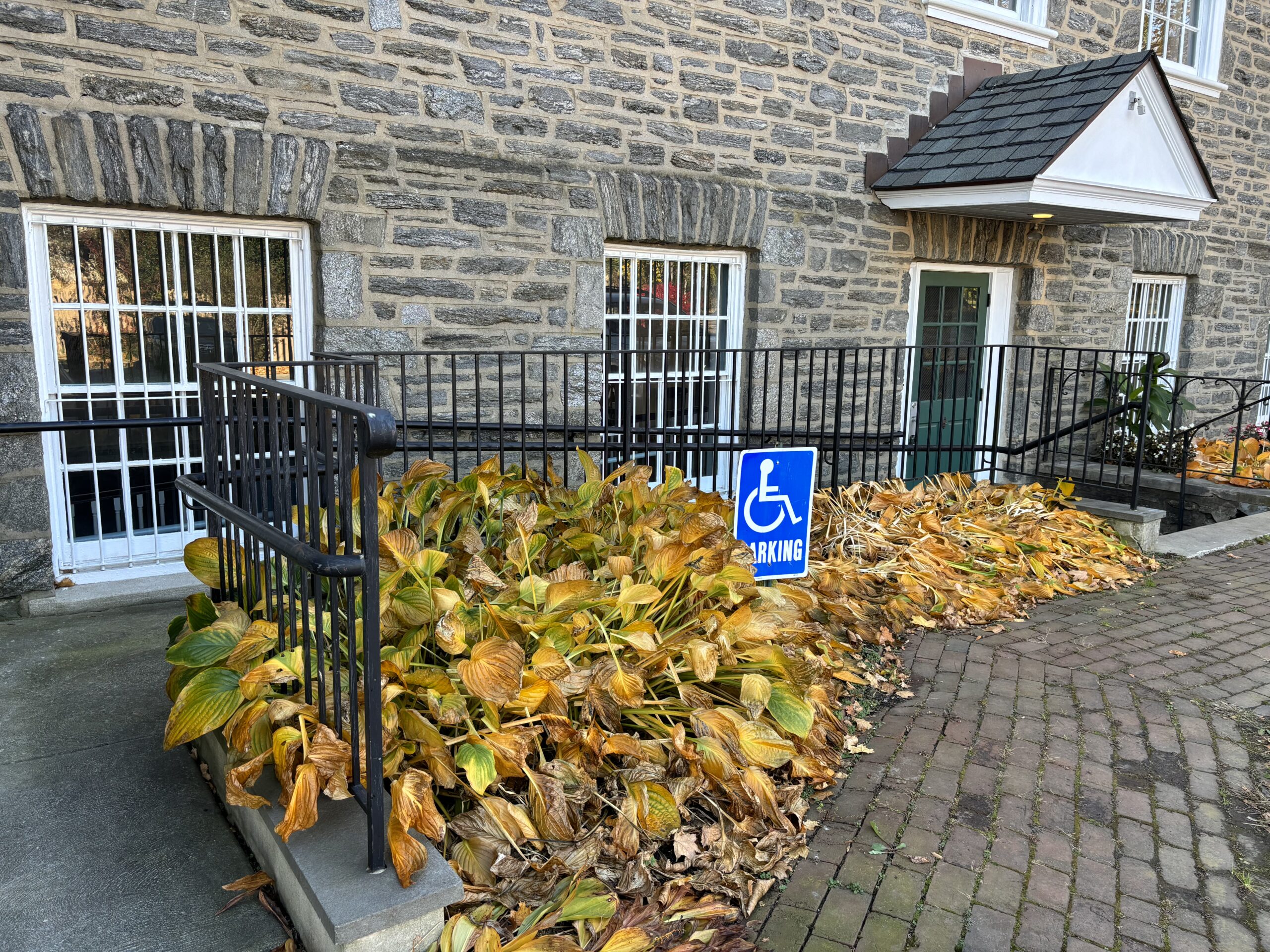 an old stone building with a ramp leading to its entrance and an accessible parking sign.