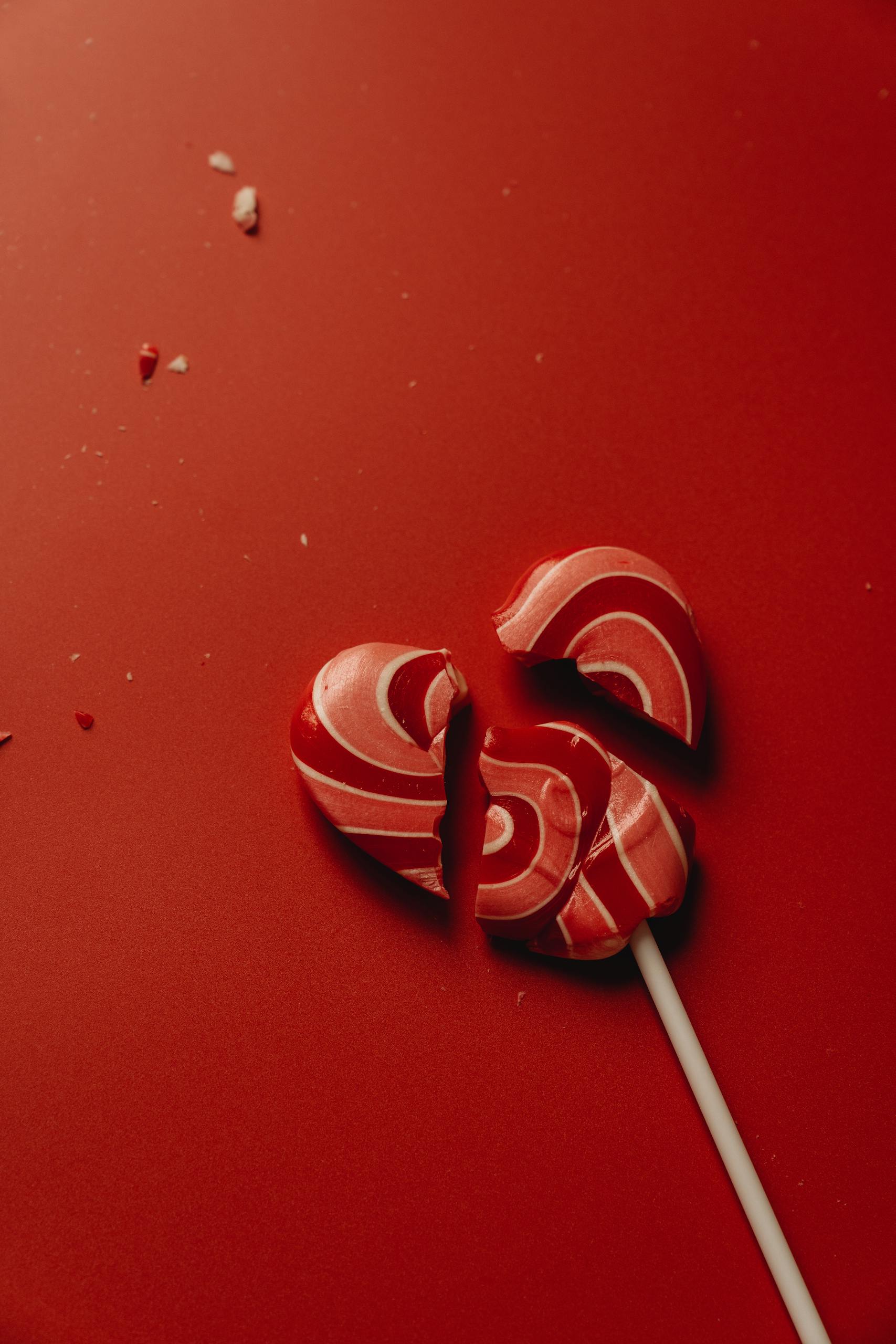 Close-Up Photo of a Red Broken Heart Shaped Lollipop