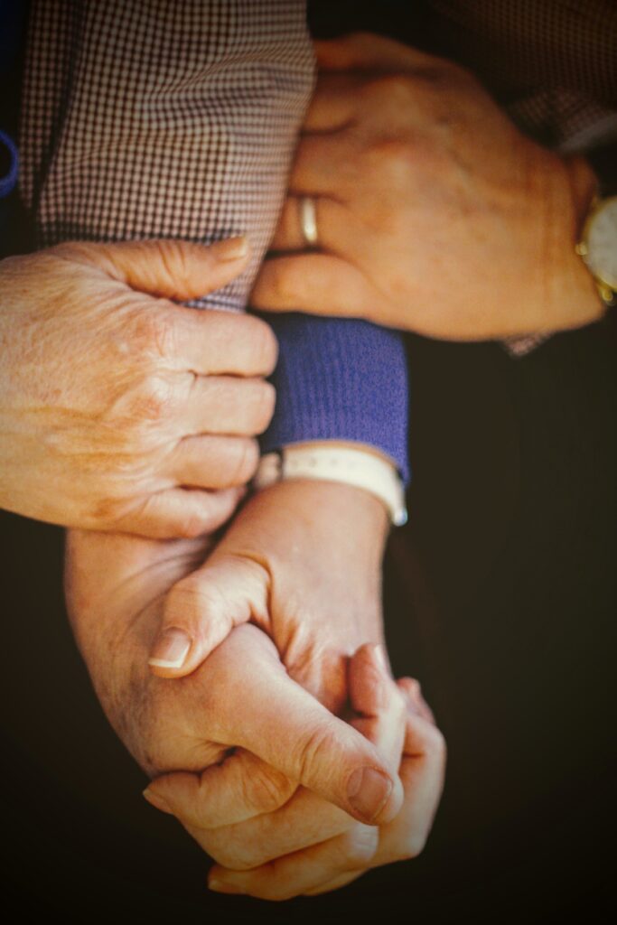 hands of multiple white people of various ages grasp each other