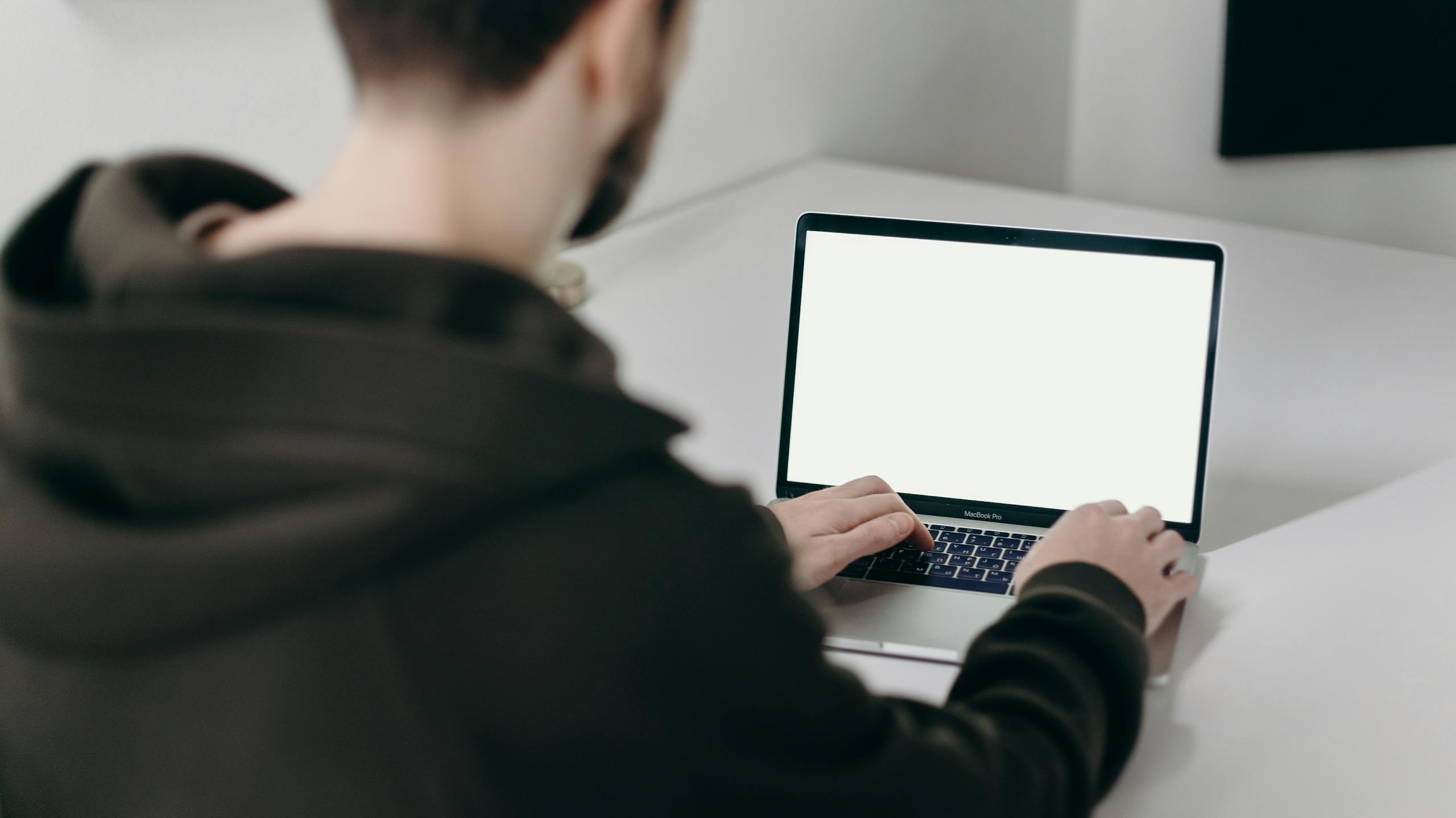 Man in Black Jacket Using a laptop.