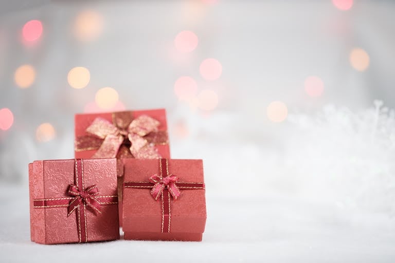 Elegant red gift boxes with ribbons and bows, set against a festive backdrop.