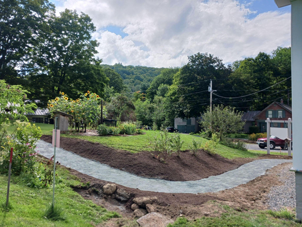 a paved, graded sidewalk cuts gently through a hill.